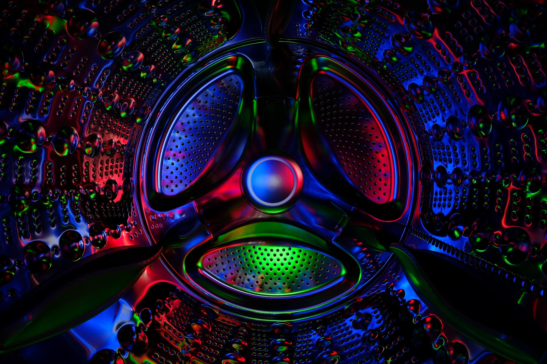 abstract inside of a clothes dryer lit by blue, red and green lights