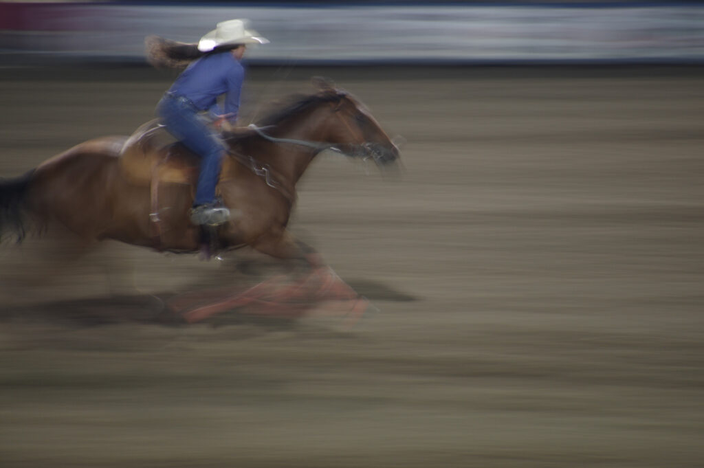 Woman on running horse in rodeo