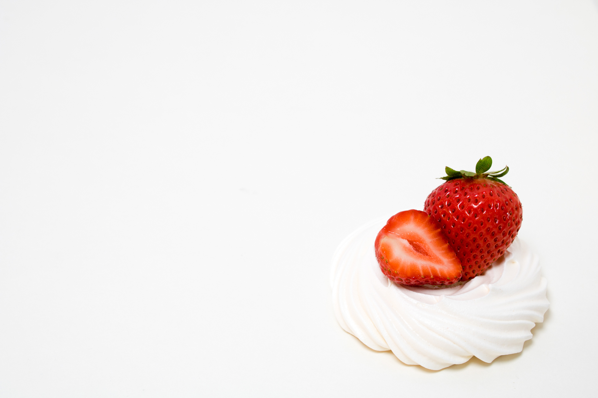 strawberries on whipped cream on a white background