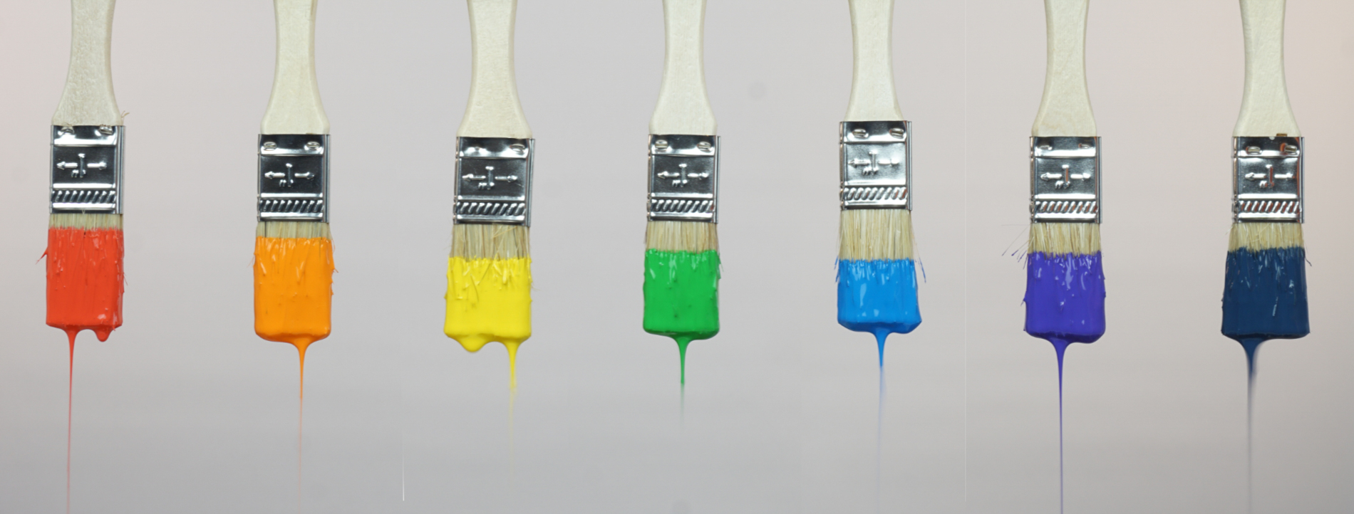 7 paintbrushes each dipped (and dripping) a color from the rainbow