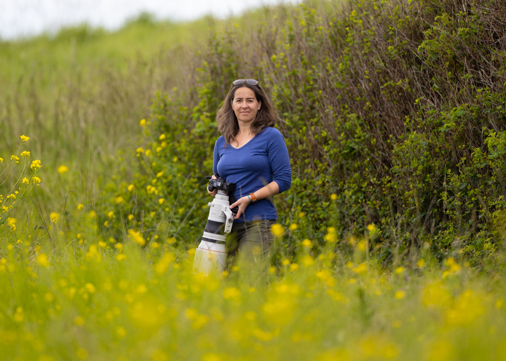 Joanna Koziara with a mighty big lens amid blooming wild mustard and coastal scrub